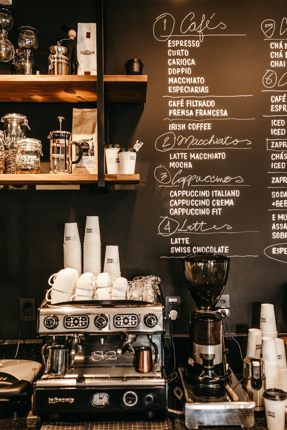 Espresso machine and grinder under a chalkboard menu