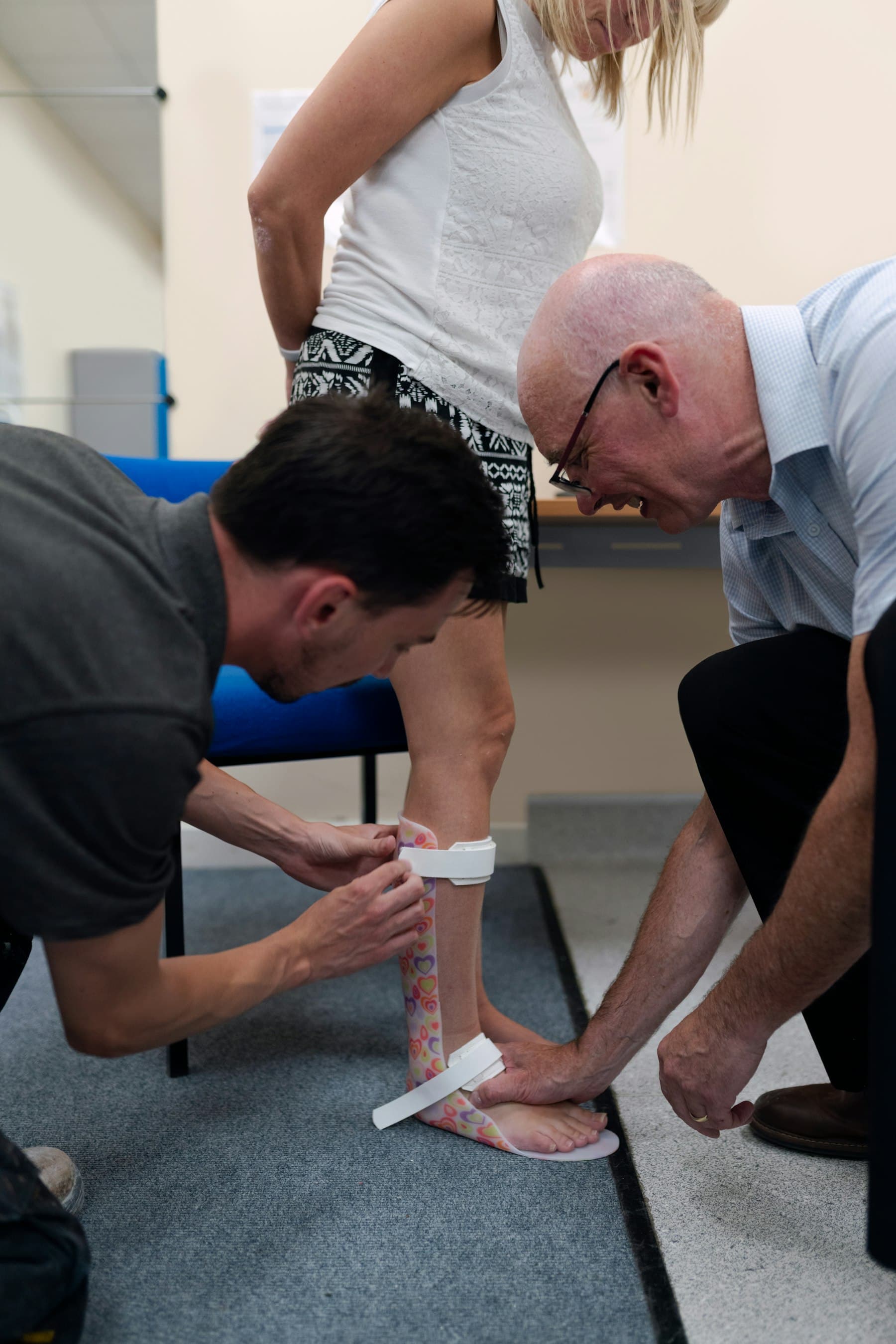 A physio taping a patient's ankle before they head back to training