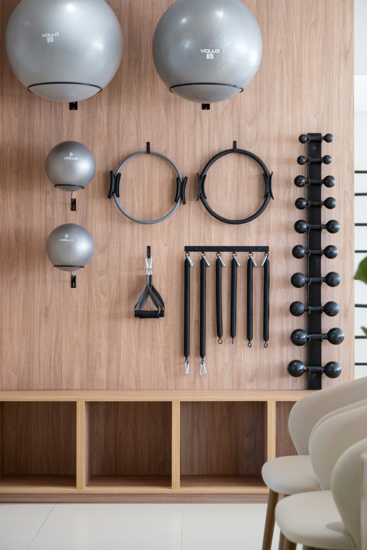 Pilates rings, balls and straps neatly hung on a timber wall